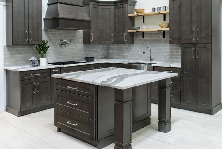 Gray stained kitchen cabinets with a marble-topped island