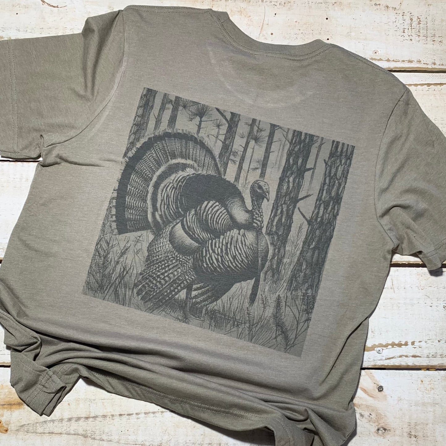 "Heather olive Bella+Canvas T-shirt featuring a vibrant Red Oak Turkey design from the Backyard to Backwoods Apparel collection, blending comfort and style for nature enthusiasts. Perfect for casual outings or embracing the outdoors with a touch of rustic charm." Back