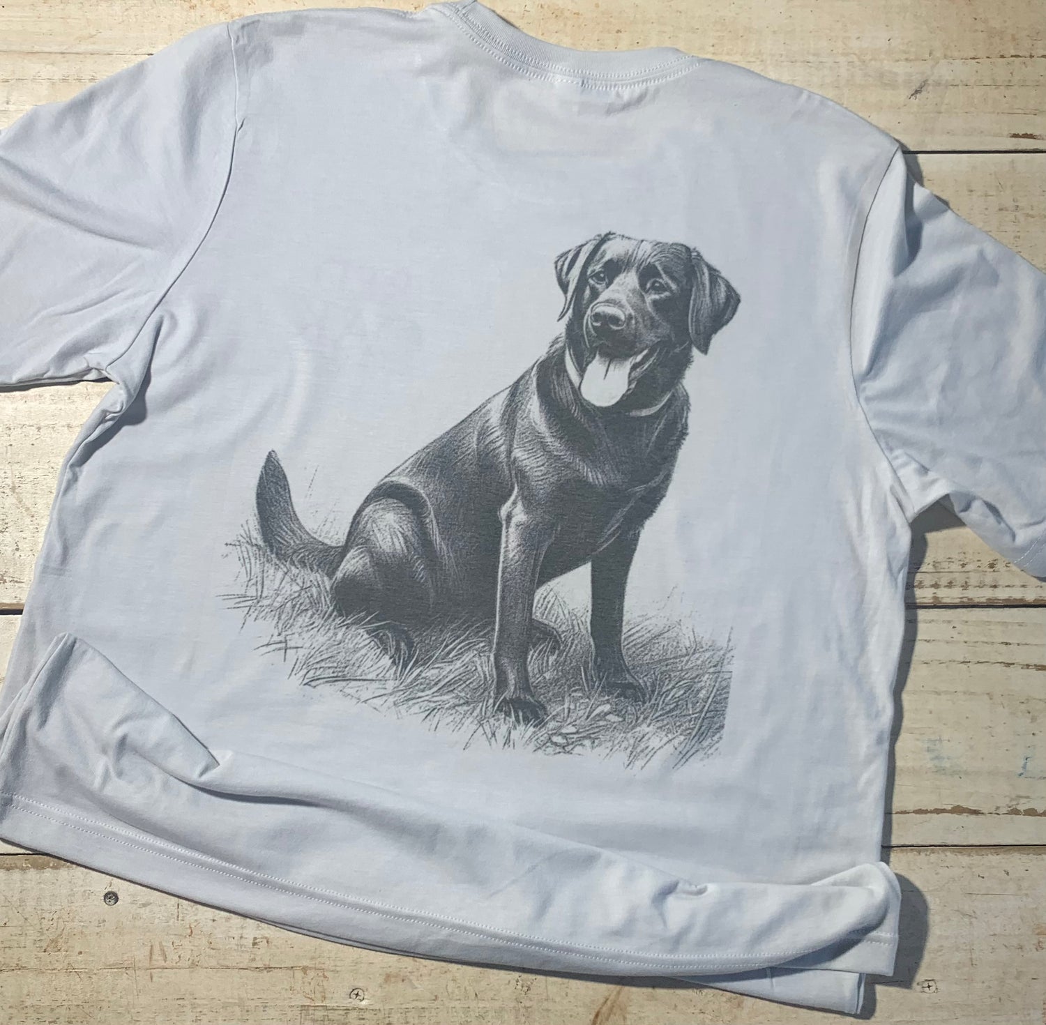 Alt Text: A Bella-Canvas silver shirt featuring a nature-inspired design titled "Red Oak Black Lab." The design showcases a majestic black lab against a backdrop of red oak trees. The premium quality fabric ensures comfort and durability, making it a versatile and stylish choice for outdoor enthusiasts. Back of shirt