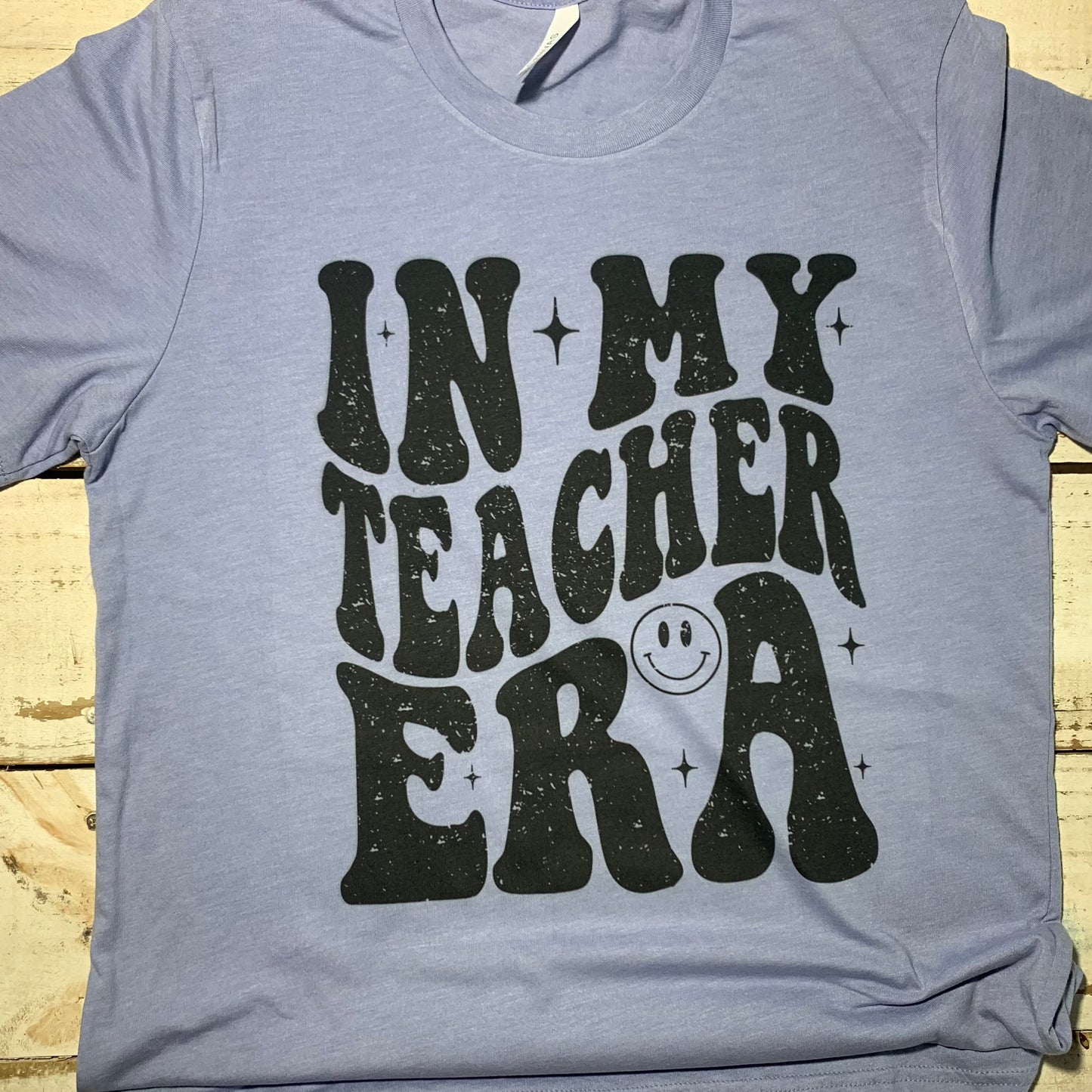 **Alt Text for "In My Teacher Era" Teacher Shirt:** "An attractive teacher shirt featuring the words 'In My Teacher Era' printed on a Bell Canvas Blue shirt. The design is a celebration of the teaching profession, with a blend of professionalism and style. The shirt is comfortable and versatile, suitable for both classroom hours and casual wear. It's a perfect gift choice for educators, symbolizing their dedication to teaching. The shirt's design reflects positivity, community, and the joy of teaching."