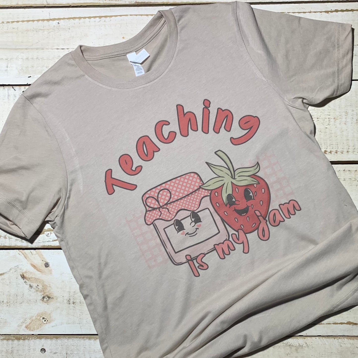 **Alt Text for Teacher Shirt Image:** "Teaching Is My Jam" teacher shirt displayed on a Bella-Canvas Heather Sand Dune shirt. The shirt features a fun and vibrant design with the words "Teaching Is My Jam" written in playful typography. The design is centered on the shirt, showcasing the teacher's dedication to their profession in a stylish and expressive way. The Heather Sand Dune color of the shirt provides a neutral and soft background, enhancing the visibility of the design."