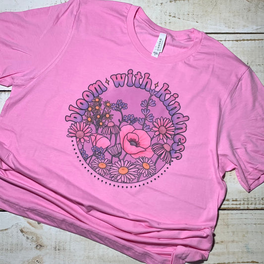 Alt Text: A Bubblegum pink Bella-Canvas T-shirt featuring the "Bloom With Kindness" graphic from Red Oak Trading Company, adorned with a vibrant floral design. The shirt is a positive statement for educators, encouraging kindness and compassion in the classroom. 🌸👩‍🏫 #TeacherStyle #KindnessBlooms