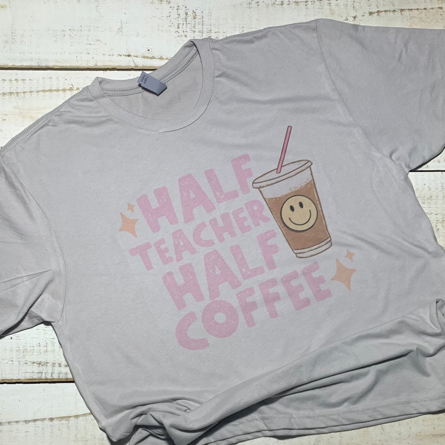 **Image Alt Text:** "Half Teacher Half Coffee Teacher Shirt" – A Bell Canvas Silver shirt with a vibrant design that showcases a coffee cup and a book, representing the perfect blend of teaching and coffee passion. The shirt is a symbol of educator identity, comfort, and style, suitable for teachers of all ages.  Shirt for Teacher.